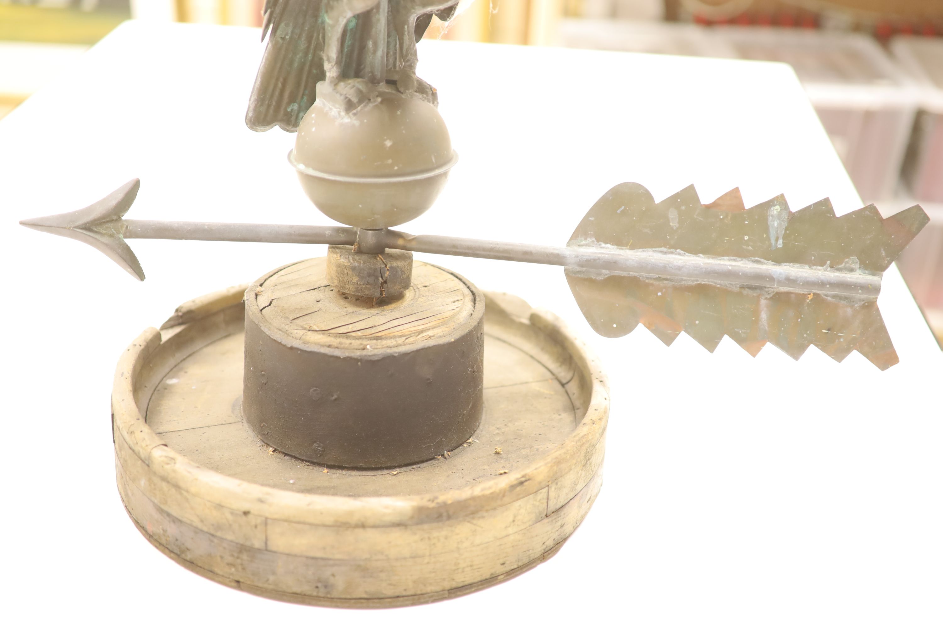 A 19th century American copper weather vane, modelled as an eagle, on an associated wooden base, width 62cm height 58cm